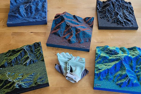 Mehrere verschiedenfarbige Geländereliefs von MTB Trails auf Holzuntergrund